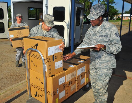 Tech Sgts. Raymond Merrow and Marcus Nakashima, and Staff Sgt. Jennifer Giles, all from the 2nd Communications Squadron, unload computers to be donated to R.V. Kerr Elementary School in Bossier City, La., May 22. The computers were military surplus and could be donated to the school under the Department of Defense's Computers for Learning program. (U.S. Air Force Photo/Tech. Sgt. Mike Andriacco)