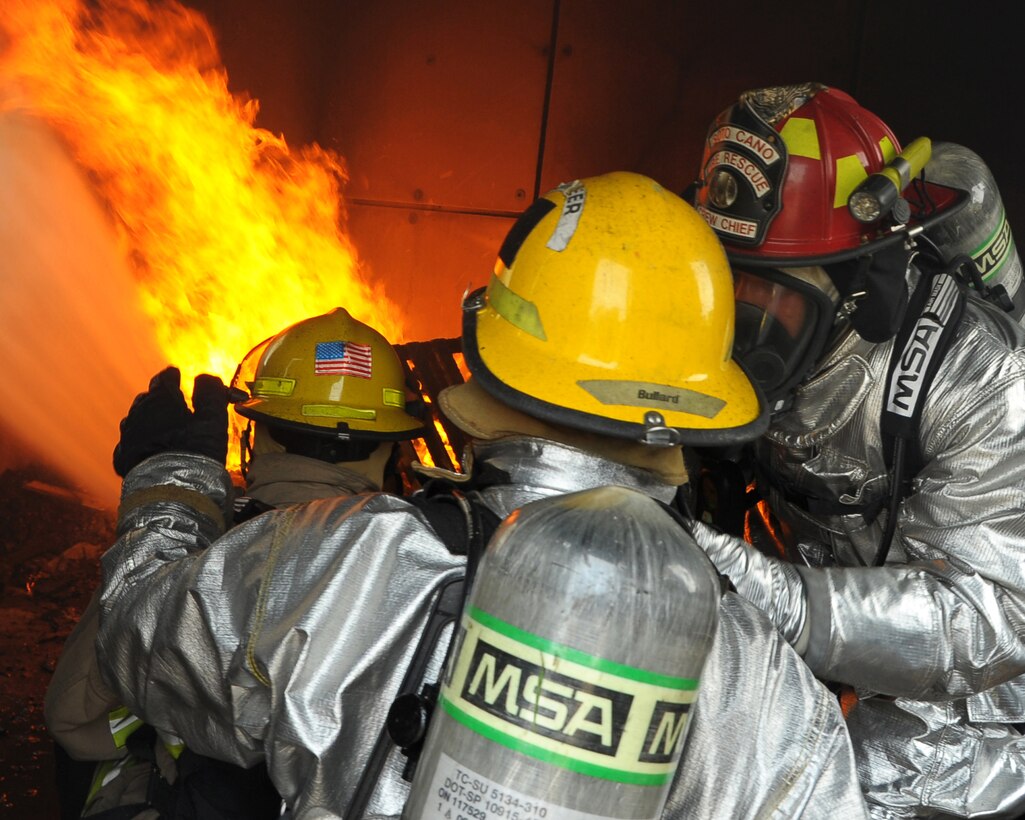 SOTO CANO AIR BASE, Honduras - Honduran firefighters put out a mock-structural fire as a U.S. Air Force firefighter instructs the pair on the procedures during Central America Sharing Mutual Operational Knowledge and Experiences (CENTAM SMOKE) exercise at Soto Cano Air Base, Honduras, May 9, 2011. CENTAM SMOKE takes place every quarter allowing firefighters from across Central America to come and share their firefighter knowledge during the four days of team-building training. (U.S. Air Force photo/Staff Sgt. Bryan Franks)