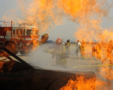 SOTO CANO AIR BASE, Honduras - Honduran firefighters put out a mock-vehicle fire as a U.S. Air Force firefighter instructs the pair on the procedures during Central America Sharing Mutual Operational Knowledge and Experiences (CENTAM SMOKE) exercise at Soto Cano Air Base, Honduras, May 8, 2011. CENTAM SMOKE allows U.S. and Honduran firefighters four days of team-building training. (U.S. Air Force photo/Staff Sgt. Bryan Franks)