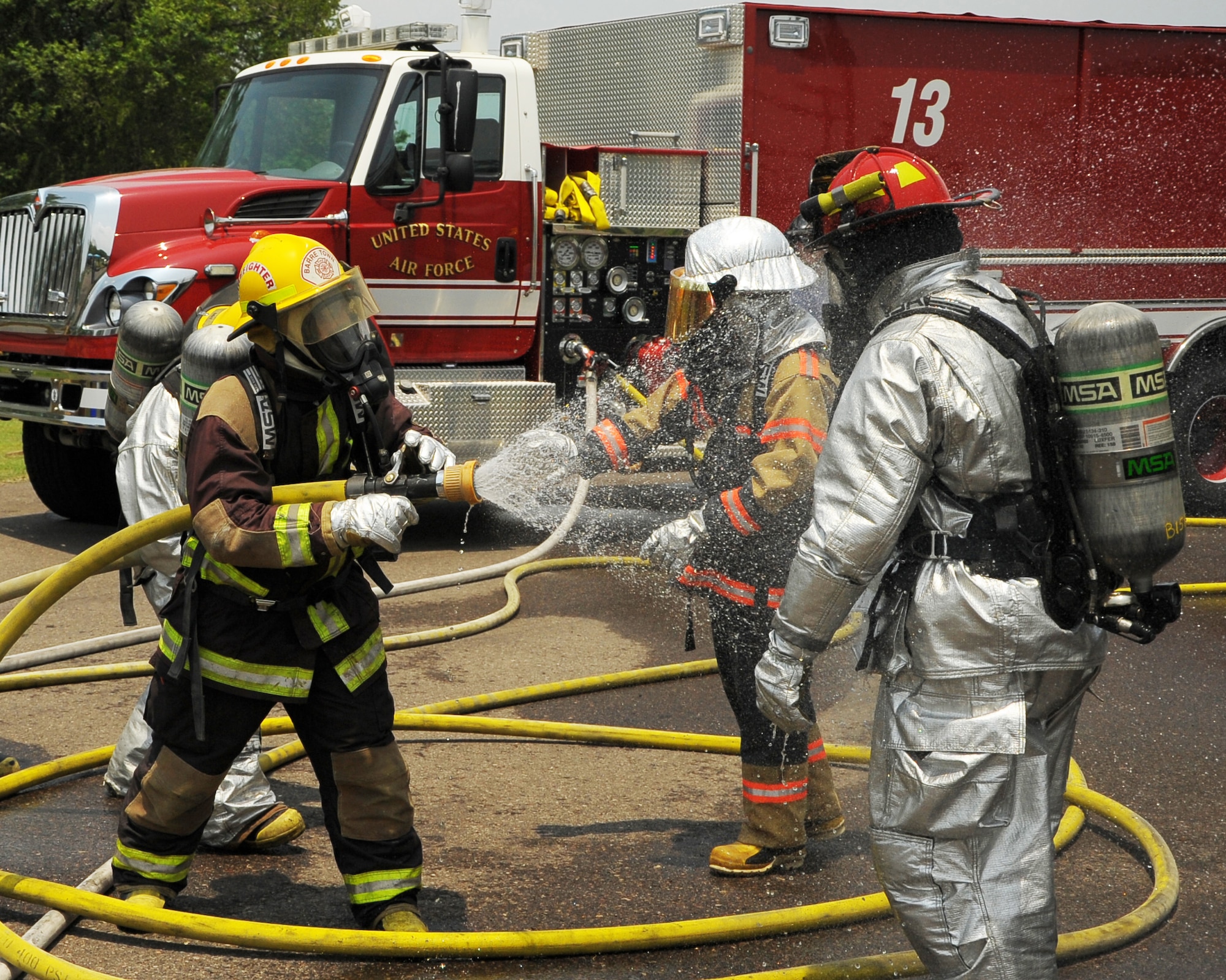 SOTO CANO AIR BASE, Honduras - A Honduran firefighter sprays down a U.S. Air Force firefighter after leaving a structure burning exercise during Central America Sharing Mutual Operational Knowledge and Experiences(CENTAM SMOKE) exercise at Soto Cano Air Base, Honduras, May 9, 2011. CENTAM SMOKE allows U.S. and Honduran firefighters four days of team-building training. (U.S. Air Force photo/Staff Sgt. Bryan Franks)