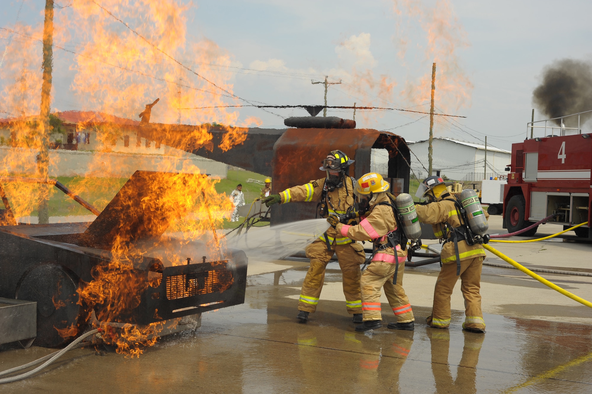 SOTO CANO AIR BASE, Honduras - Honduran firefighters put out a mock-vehicle fire as a U.S. Air Force firefighter instructs the pair on the procedures during Central America Sharing Mutual Operational Knowledge and Experiences (CENTAM SMOKE) exercise at Soto Cano Air Base, Honduras, May 8, 2011. CENTAM SMOKE allows U.S. and Honduran firefighters four days of team-building training. (U.S. Air Force photo/Staff Sgt. Bryan Franks)