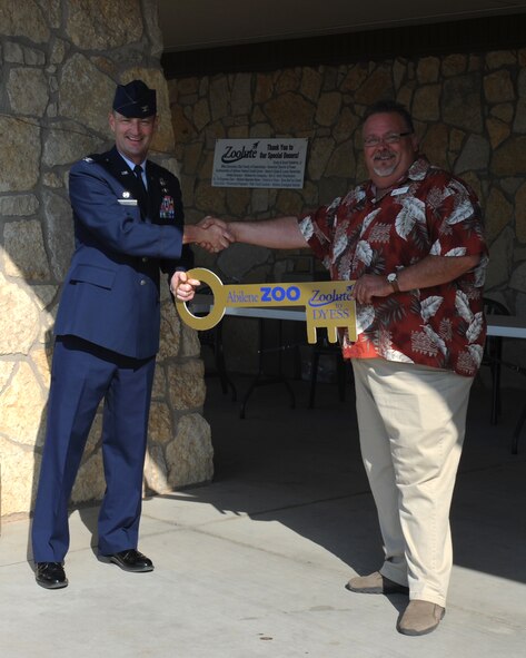 U.S. Air Force Col. David Béen, left, 7th Bomb Wing commander, receives a key to the Abilene Zoo from Bill Gersonde, Abilene Zoo director, during the annual “Zoolute to Dyess” May 19, 2012, in Abilene, Texas. The Abilene Zoological Society hosted the event to show appreciation to all military members and their families. The event included free food and admission to the zoo. (U.S. Air Force photo by Staff Sgt. Richard P. Ebensberger/ Released)