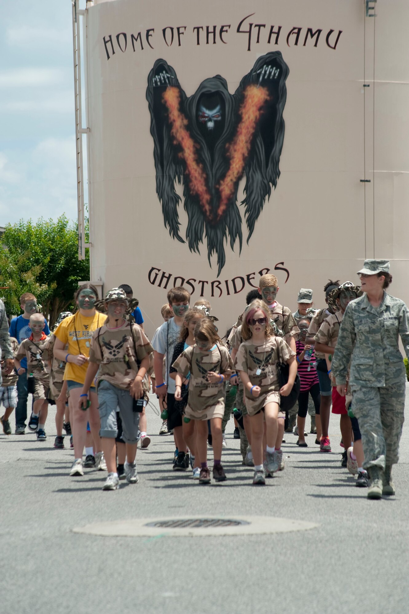Airman 1st Class Ashley Coe, a pediatrics technician from 1st Special Operations Medical Operations Squadron, leads a formation of children during the Kids Understanding Deployment Operations event outside the Commando Hangar at Hurlburt Field, Fla., May 19, 2012. At the end of the KUDOS event, parents welcomed their children back from a mock deployment. (U.S. Air Force photo/Airman 1st Class Benjamin Kim)(RELEASED)