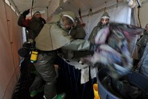 MINOT AIR FORCE BASE, N.D. -- Airmen from the 5th Medical Group  prepare to simulate decontaminating a patient by removing their contaminated clothing during a major accident response exercise here May 17. With 55 mock casualties as part of the scenario, the entire medical group had their work cut out for them as the first line responders for medical support. (U.S. Air Force photo/Senior Airman Brittany Y. Auld)