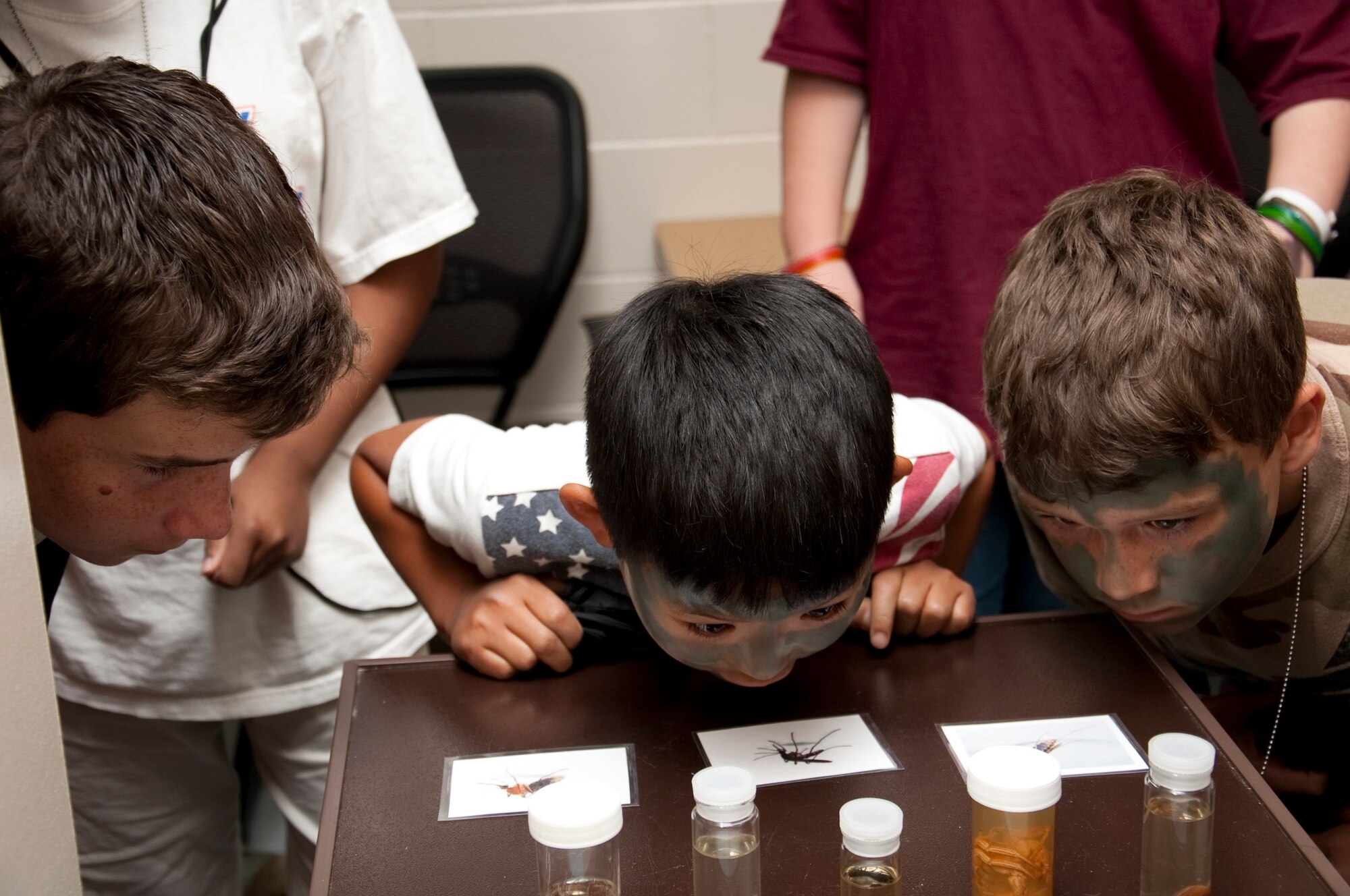 Children inspect various insects that Airmen may encounter during deployment at the Kids Understanding Deployment Operations event at the base Deployment Control Center at Hurlburt Field, Fla., May 19, 2012. The section is one of various booths at KUDOS designed to show kids what Airmen during the pre-deployment process.  (U.S. Air Force photo/Airman 1st Class Benjamin Kim)(RELEASED)