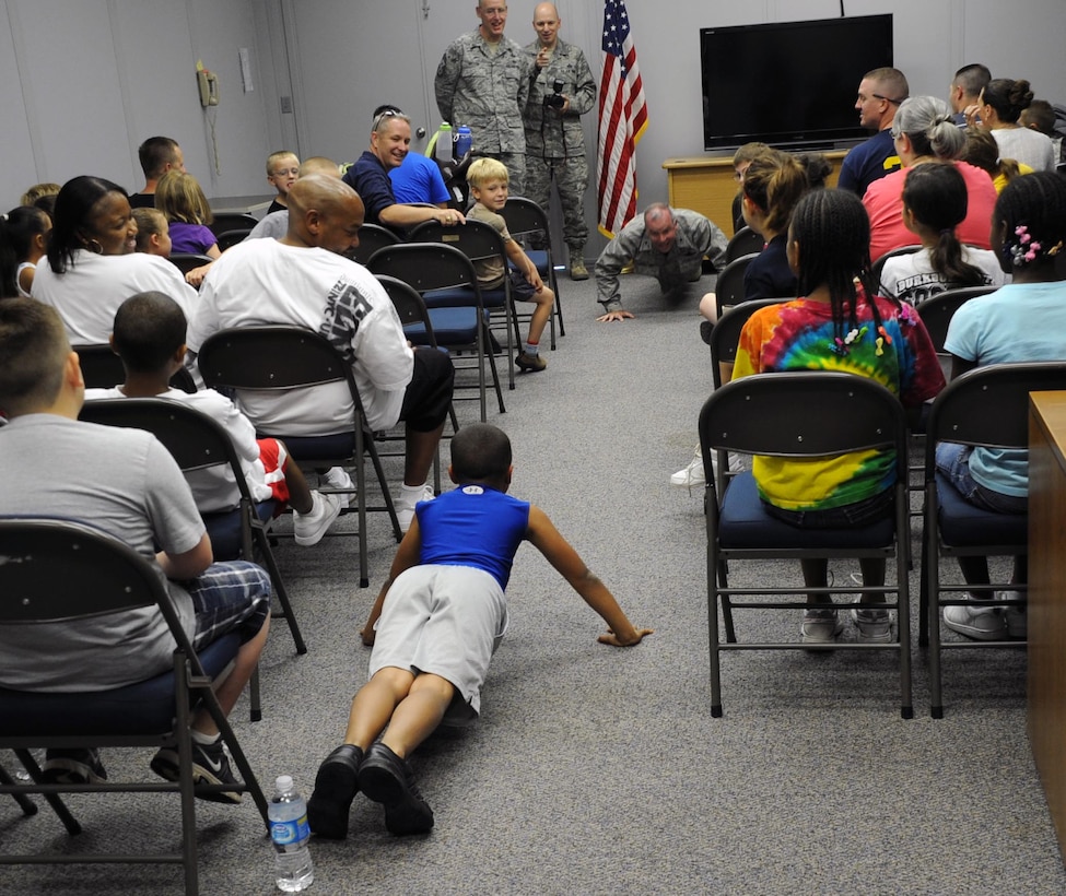 Brig. Gen. Michael Fantiniis challenged to do some push-ups during Operation KIDS May 19.  Operation KIDS (Kids Investigating Deployment Services) gives children a chance to see what their parents may go through on a deployment.