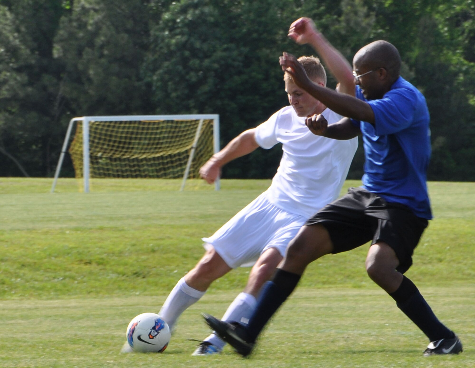 Les Wilson, the Langley Air Force Base Soccer team midfielder and striker wearing white, prepares to pass the ball to a teammate in the second half of the season ending game against the Wyld Stallyns in Yorktown, Va., May 12,2012. The Langley Soccer Club is an all-military JBLE-affiliated soccer team coached by retired military members. (U.S. Air Force photo by Airman 1st Class R. Alex Durbin/Released)