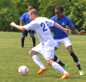Daniel Hoyos, the Langley Air Force Base Soccer team midfielder wearing, dribbles the ball past a Wyld Stallyns defender shortly before scoring a goal during their last regular season game, played at Yorktown, Va., May 12, 2012. The Raptors won the game 22-0 qualifying the team for the league’s playoffs starting May 13, 2012. (U.S. Air Force photo by Airman 1st Class R. Alex Durbin/Released)