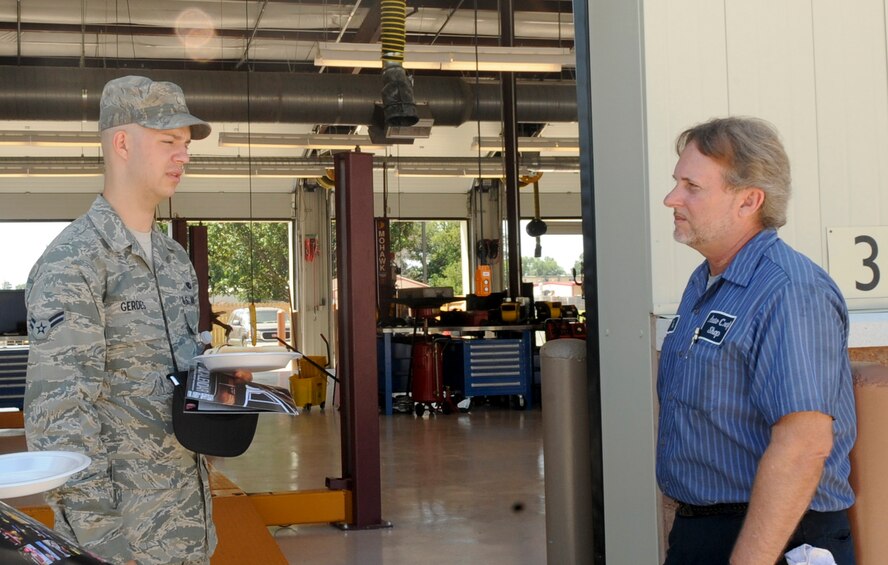 Airman 1st Class Nathaniel Gerdes, 2nd Maintenance Squadron crew chief, speaks with Tom Hunnicutt, 2nd Force Support Squadron mechanic, at the grand opening of the Auto Hobby Shop on Barksdale Air Force Base, La., May 22. The new building features 10 workstations for auto hobbyists to perform routine maintenance and repair, along with a new automatic car wash. (U.S. Air Force photo/Senior Airman Kristin High)(RELEASED)