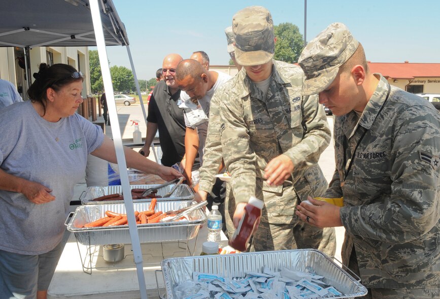 Team Barksdale members enjoy free hot dogs, chips and soda at the grand opening of the Auto Hobby Shop on Barksdale Air Force Base, La., May 22. The new facility replaced the original auto shop that was built in 1932 and is listed on the National Historic Registry preventing renovation work from being accomplished on that building to meet the demands of the base population. . The new building features 10 workstations for auto hobbyists to perform routine maintenance and repair, along with a new automatic car wash. (U.S. Air Force photo/Senior Airman Kristin High)(RELEASED)