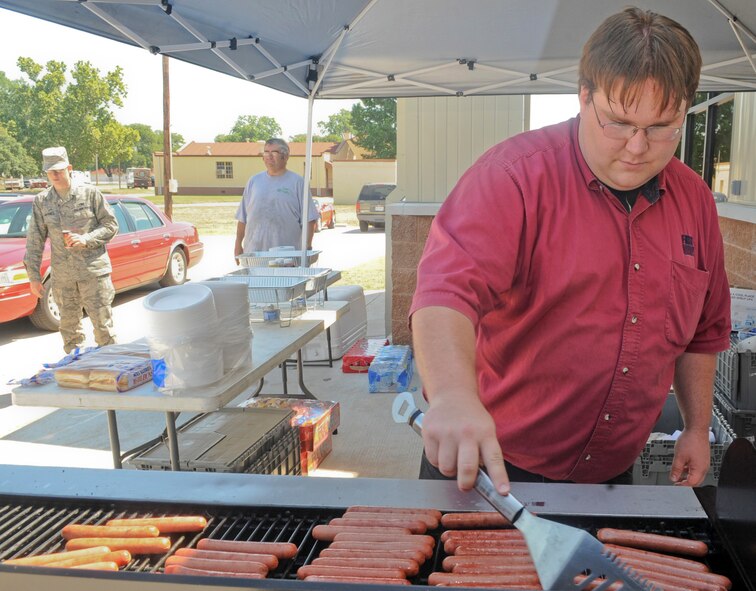 Jody Stevens, O'Reilly Auto Parts mechanic, grills hot dogs at the grand opening of the Auto Hobby Shop on Barksdale Air Force Base, La., May 22. The new building has 10 workstations for auto hobbyists to perform routine maintenance and repair, along with a new car wash. (U.S. Air Force photo/Senior Airman Kristin High)(RELEASED)