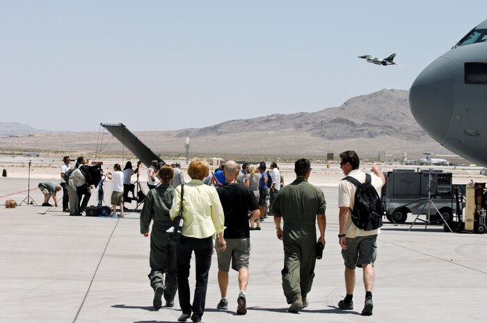 Crew members from Gurasich Spence Darilek and McClure advertising agency head to a C-17 during filming May 15, 2012, at Nellis Air Force Base, Nev for "Rapid Strike," a recruiting truck tour. “It’s going to be what we call the simulator tour,” said Tom Gilmore, Account Director for GSD&M. “It’s going to go on the road in September, but the idea of it is a truck with a pod on it capsule that will seat about 14 people and it’s on hydraulics and so they go in there sit and the pod moves around while they watch a movie.” (U.S. Photo by Senior Airman Jack Sanders)