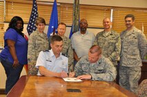 Col. Laen August (left) and Lt. Col. Phil Heseltine (right) sign the memorandum of understanding between the 916th Air Refueling Wing and 911th Air Refueling Squadron in mid-May. August is the commander of the 916ARW and Heseltine is the commander of the 911ARS. (USAF photo by Maj. Shannon Mann, 916ARW/PA, released)