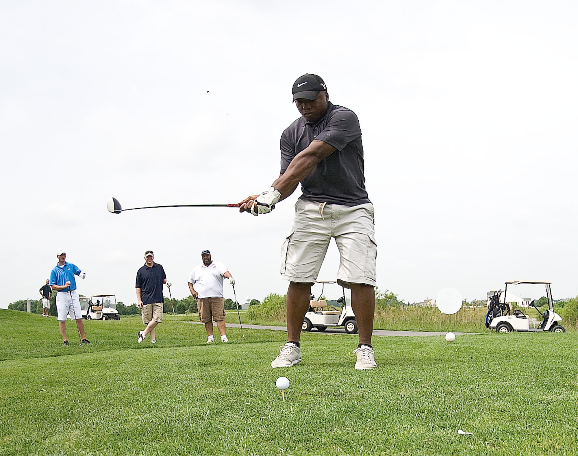 Senior Airman Warren Bush, middle, tees off during the Bluesuiter’s Golf Tournament May 16, 2012, at Jonathan’s Landing Golf Course in Magnolia, Del. The Bluesuiter’s Golf Tournament is a biannual tournament with a goal of bringing Team Dover members and the local community closer together. (U.S. Air Force photo by Senior Airman Jacob Morgan)