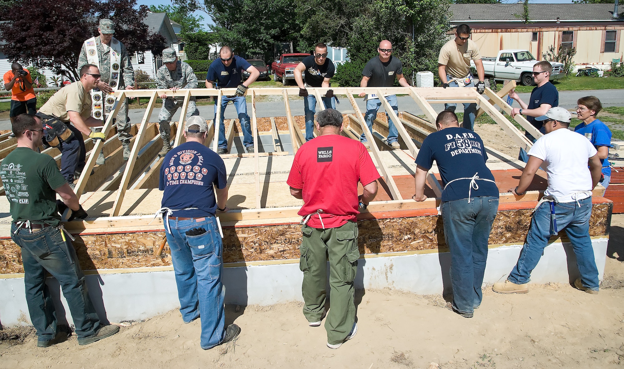 Volunteers from Dover Air Force Base, Del., and the local community lift the first wall on a new Habitat for Humanity home May 19, 2012, in Frederica, Del. Members from the 436th Airlift Wing Staff Agencies, 436th Medical Group, 9th Airlift Squadron and 436th Security Forces Squadron all attended. The home for Ariel Baynard and her family is being built over the next two months with involvement from every squadron at Dover AFB. (U.S. Air Force photo by Senior Airman Jacob Morgan)
