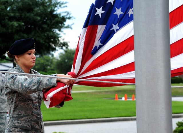 Airman 1st Class Heather Ives, 628th Security Forces Squadron, lowers the flag during the “National Police Week” retreat ceremony May 18, 2012 at Joint Base Charleston, S.C. During National Police Week, Security Forces members honor law enforcement personnel who have fallen.  Joint Base Charleston held other activities and events for Police Week to include a ‘Guns and Hoses’ competition against the 628th Civil Engineer Squadron and a Chili Cook Off. (U.S. Air Force photo/Airman 1st Class Ashlee Galloway)
