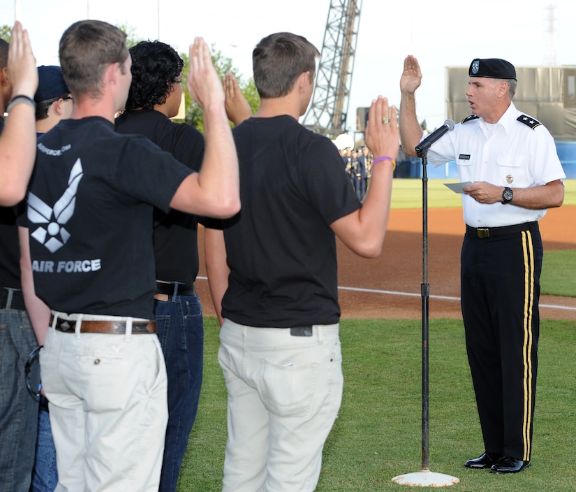 U.S. Army Maj. Gen. Frederick Rudesheim, Joint Staff Joint and Coalition Warfighting deputy director, administers the Oath of Enlistment to 20 military Delayed Entry Program participants during the opening ceremony of the Norfolk Tides’ 17th annual Armed Forces Night at Harbor Park Stadium in Norfolk Va., May 19, 2012. The event honored Service members from all branches of the Armed Forces within the local community. (U.S. Air Force photo by Airman 1st Class Teresa Cleveland/Released)