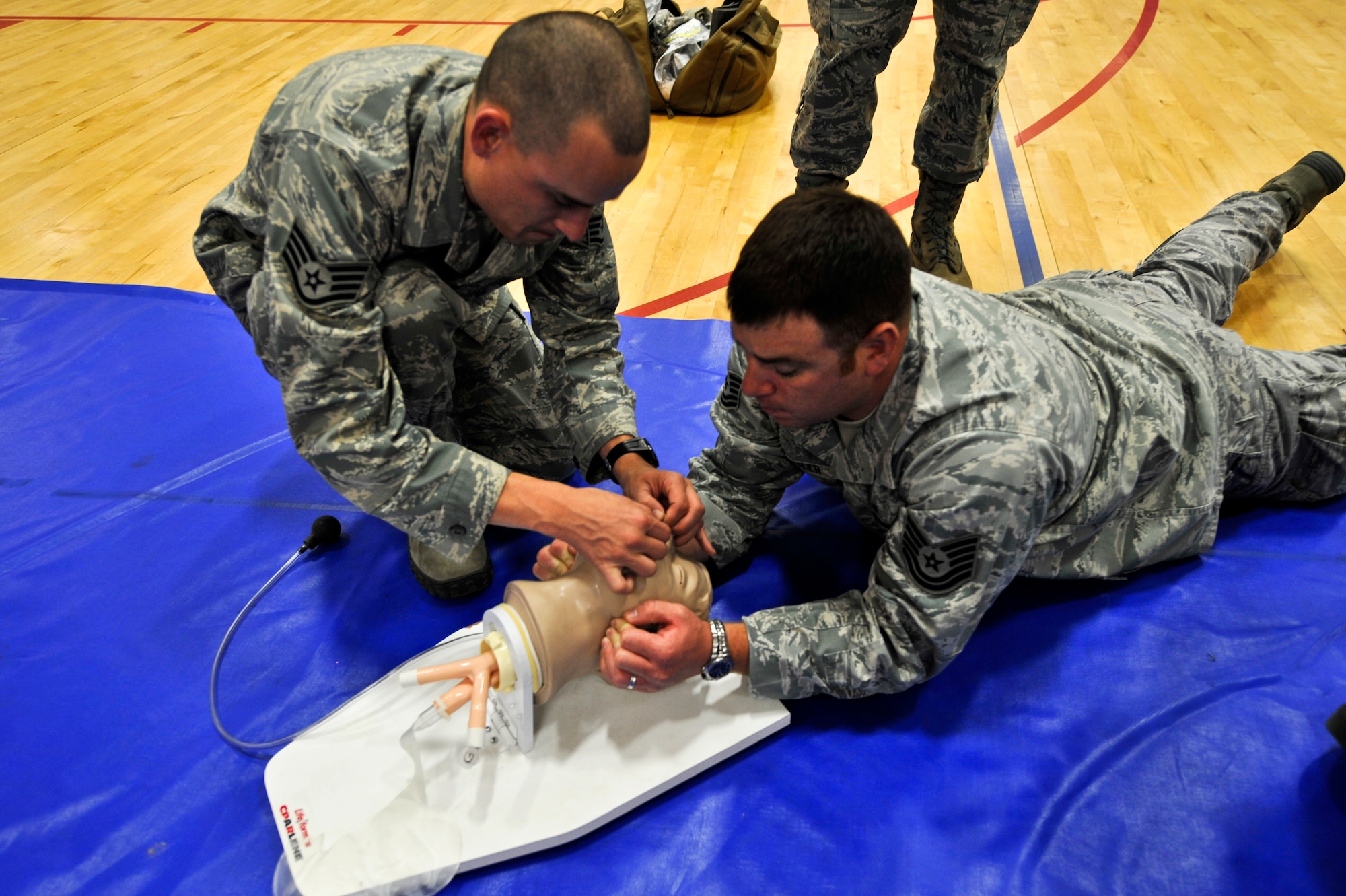 BUCKLEY AIR FORCE BASE, Colo. – Staff Sgt. Jared Atencio, left, 460th Space Communication Squadron, inserts a nasopharyngeal airway while Tech. Sgt. Jason Schuler, 460th Security Forces Squadron, supports the head of his patient during the 460th Space Wing's Operational Readiness Inspection, May 16, 2012.  Self-aid buddy care was one of the many things inspected during the ORI.  (U.S. Air Force photo by Airman 1st Class Riley Johnson)