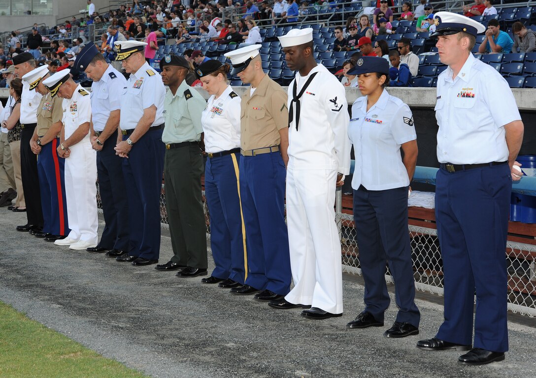 U.S. Service members pause to observe a moment of silence during the opening ceremony of the Norfolk Tides’ 17th annual Armed Forces Night at the Harbor Park Stadium in Norfolk, Va., May 19, 2012. The Tides host the event each year to honor Service members from all branches of the Armed Forces. (U.S. Air Force photo by Airman 1st Class Teresa Cleveland/Released)