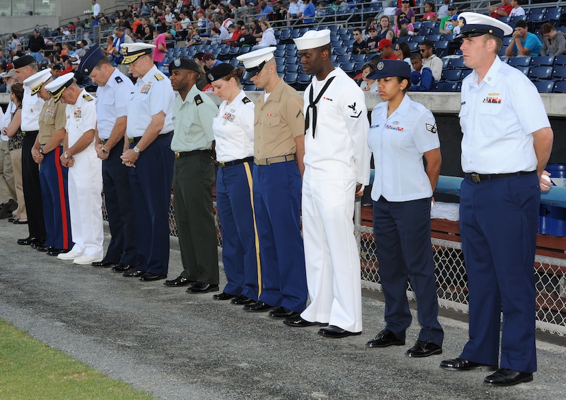 U.S. Service members pause to observe a moment of silence during the opening ceremony of the Norfolk Tides’ 17th annual Armed Forces Night at the Harbor Park Stadium in Norfolk, Va., May 19, 2012. The Tides host the event each year to honor Service members from all branches of the Armed Forces. (U.S. Air Force photo by Airman 1st Class Teresa Cleveland/Released)