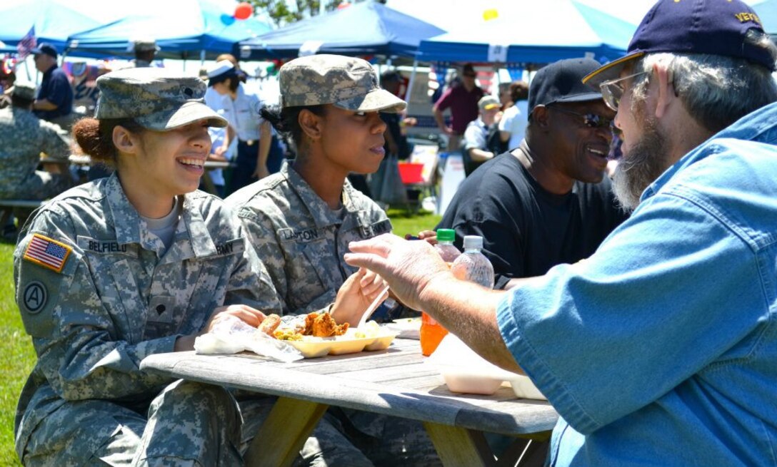 U.S. Army Spc. Ashley Belfield and Sgt. Victoria Lampton, assigned the 7th Sustainment Brigade personnel section, enjoy lunch with veterans during the county fair hosted by the Veterans Affairs Medical Center in Hampton, Va., May 9, 2012. The Soldiers 'buddied up' with local veterans, volunteers and patients alike during a county fair hosted by the medical center. (U.S. Army photo by Sgt. Edwin Rodriguez/Released)