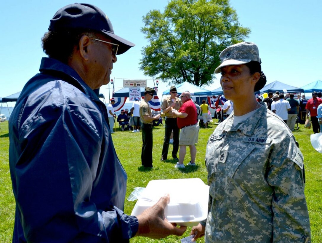U.S. Army Sgt. 1st Class Johnna Covington, assigned to the 7th Sustainment Brigade maintenance readiness section, speaks to Dexter Cutler, a volunteer at the county fair hosted by the Veterans Affairs Medical Center in Hampton, Va., May 9, 2012. Volunteers from the 7th Sus. Bde. attended the event, which offered games, prizes, food and music. (U.S. Army photo by Sgt. Edwin Rodriguez/Released)