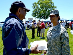 U.S. Army Sgt. 1st Class Johnna Covington, assigned to the 7th Sustainment Brigade maintenance readiness section, speaks to Dexter Cutler, a volunteer at the county fair hosted by the Veterans Affairs Medical Center in Hampton, Va., May 9, 2012. Volunteers from the 7th Sus. Bde. attended the event, which offered games, prizes, food and music. (U.S. Army photo by Sgt. Edwin Rodriguez/Released)