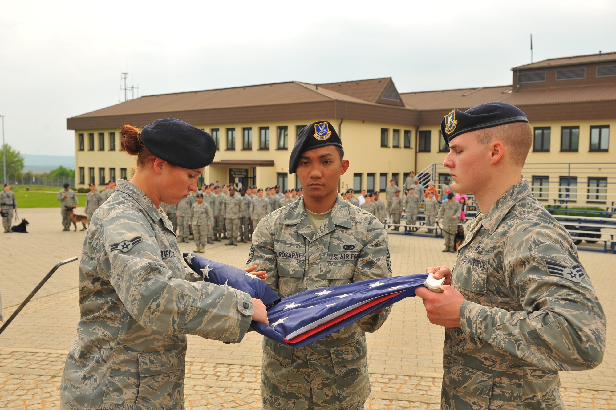 SPANGDAHLEM AIR BASE, Germany – From left to right, Airman 1st Class Bronwyn Bartechko, Staff Sgt. Julious Del Rosario and Senior Airman Robert Neff, 52nd Security Forces Squadron patrolmen, fold an American flag during the National Police Week retreat ceremony outside the wing headquarters building here May 21. The ceremony consisted of the playing of retreat followed by the German and American national anthems and the lowering of each country’s flag. The ceremony closes National Police Week by honoring law enforcement members who gave their life for the safety and protection of others. (U.S. Air Force photo by Airman 1st Class Dillon Davis/Released)