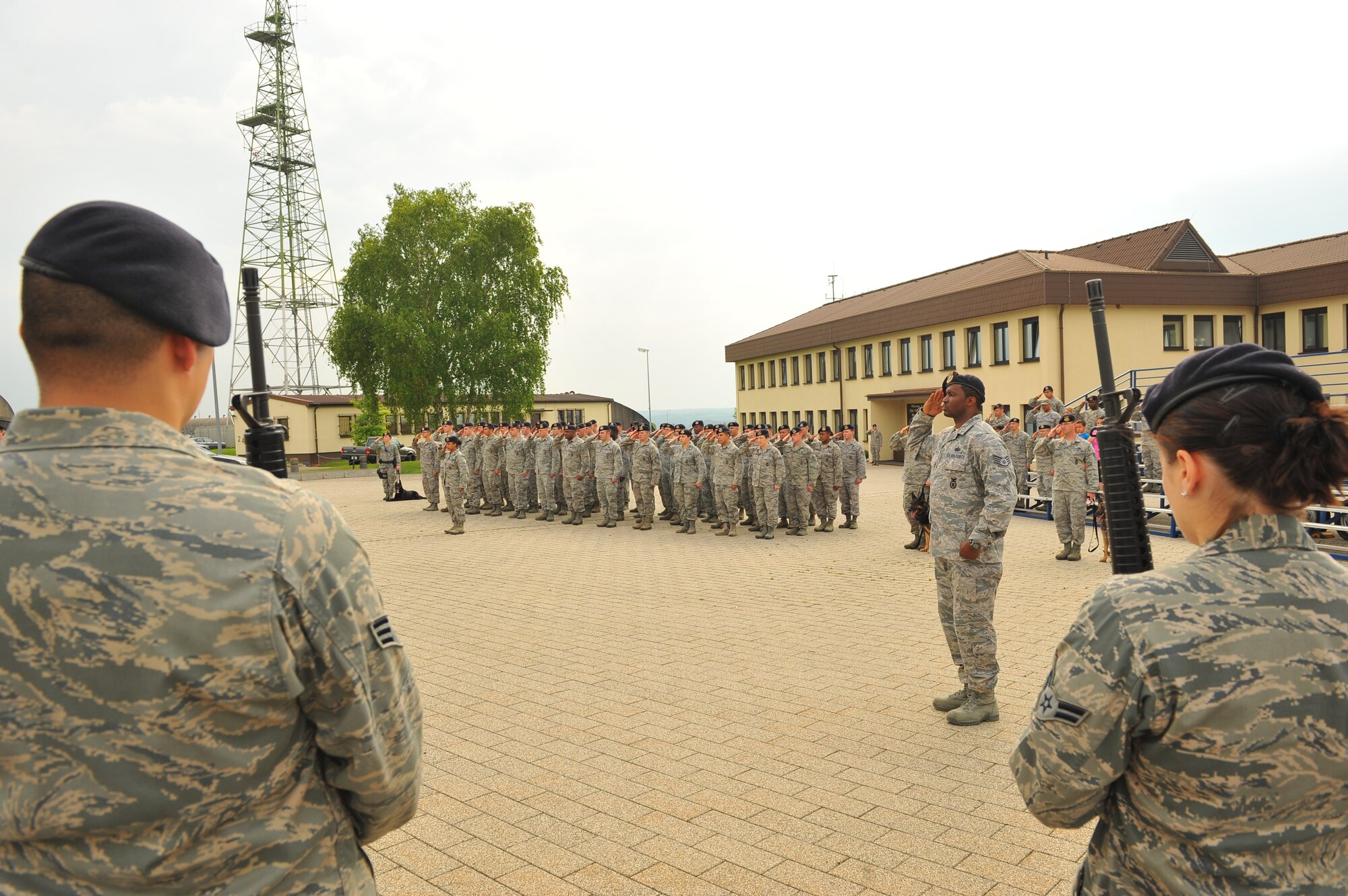 SPANGDAHLEM AIR BASE, Germany – Airmen from the 52nd Security Forces Squadron salute during the playing of the German and American national anthems at the National Police Week retreat ceremony outside the wing headquarters building here May 21. The ceremony consisted of the playing of retreat followed by the national anthems and the lowering of each country’s flag. The ceremony closes National Police Week by honoring law enforcement members who gave their life for the safety and protection of others. (U.S. Air Force photo by Airman 1st Class Dillon Davis/Released)