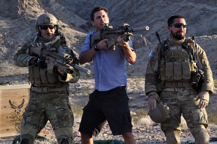 Derin Seale, a Digital Domain Productions director, explains the angle he would like Combat Controllers to stand at while holding a Special Operations Forces Combat Assault Rifle, or SCAR, during filming of an Air Force Recruiting Service project May 17, 2012 at Nellis Air Force Base, Nev. Seale was part of a 50-person production crew which filmed footage for an interactive recruiting service simulator with several Nellis units from May 14-20. The simulator will put public audiences at the center of a fictional mission in which they can see the various roles and capabilities the Air Force provides. (U.S. Air Force photo by Benjamin Newell, Released)