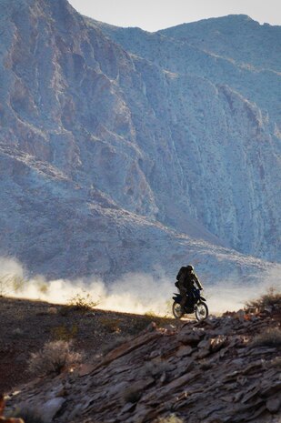 An Air Force Combat Control Team member drives a desert dirt bike along a ridgeline trail May 17, 2012, at Nellis Air Force Base, Nev. CCT members simulated an airdrop into a combat zone followed by cross country movement to a ground target during filming in support of an Air Force Recruiting simulator project. Through a simulator ride, the project will provide the public a first-hand glimpse at the missions the Air Force performs, including the special operations missions CCTs carry out in real life. (U.S. Air Force photo by Benjamin Newell, Released)