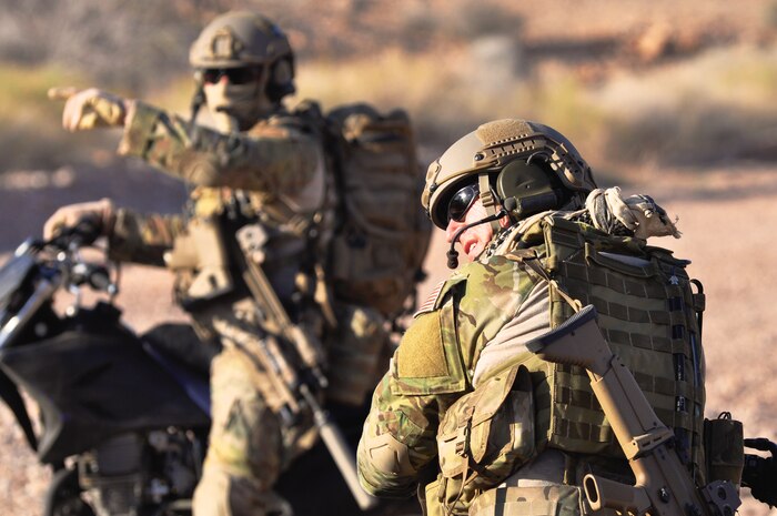 Air Force Special Operations Combat Control Team members discuss their driving route while seated atop desert dirt bikes during a film shoot May 17, 2012 at Nellis Air Force Base, Nev. Combat Control Team members helped recreate a hypothetical Air Force mission during filming for a simulator ride project the Air Force Recruiting Service will use to inform and educate the public on the Air Force's capabilities. (U.S. Air Force photo by Benjamin Newell, Released)