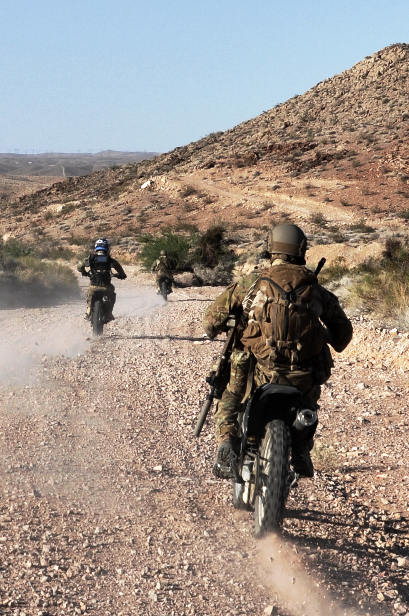 Air Force Special Operations Combat Control Team members ride desert dirt bikes alongside stunt performer Devin Blackwell during a film shoot May 17, 2012 at Nellis Air Force Base, Nev. The stunt performer helped the CCT members apply their versatile driving skills, which enable them to adapt on-the-fly to unknown situations during deployments to austere locations worldwide, into a visually exciting scene that will be incorporated into a recruiting simulator ride. The simulator will help the Air Force Recruiting Service explain the Air Force mission to the public through personal experience. (U.S. Air Force photo by Benjamin Newell, Released)
