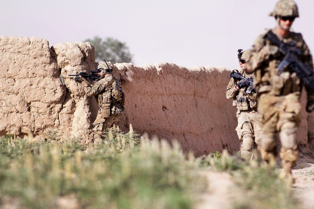 U.S. Army Staff Sgt. Justin Boardman provides cover security as fellow ...