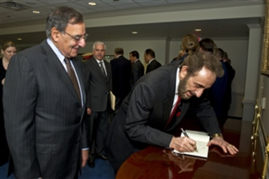 U.S. Defense Secretary Leon E. Panetta watches as acting Iraqi Defense Minister Sadun al-Dulaymi writes a message in the guest book at the Pentagon, May 22, 2012.