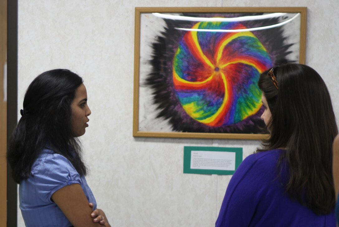 Guests discuss art an art exhibit held by Naval Hospital Camp Lejeune's Virginia Dare Annex, May 3. The art was done by service members in the annex's art therapy program. 