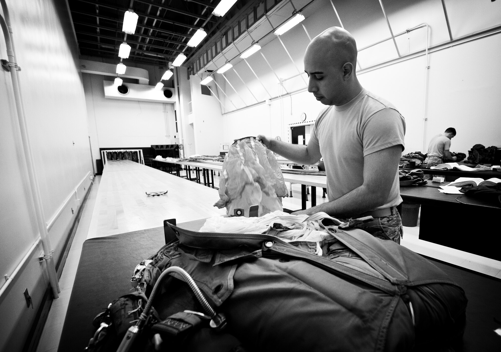 YOKOTA AIR BASE, Japan -- Senior Airman Phillip Rodriguez, 374th Operations Support Squadron aircrew flight equipment journeyman, packs a parachute after repairs at Yokota Air Base, Japan, May 21, 2012. Inspecting, repairing and packing a parachute can take up to three hours. (U.S. Air Force photo by Airman 1st Class Krystal M. Garrett)