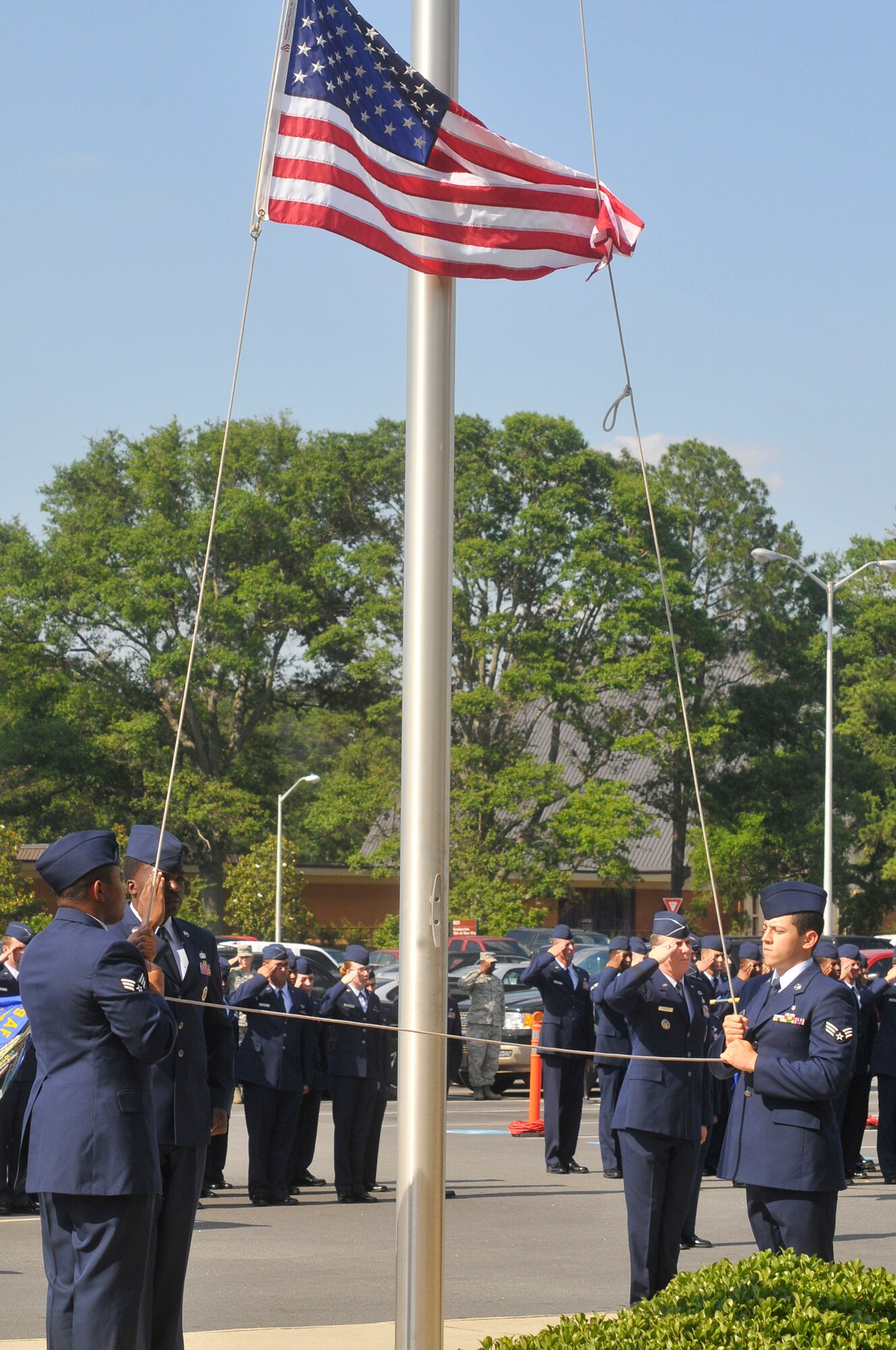 L-R, Senior Airman Terrell Ferguson, Staff Sgt. Nicholas Jackson and Senior Airman Mario Benavidez attend to lowering the flag during a  Memorial Day Retreat Ceremony Wed. The retreat included representatives of every organization on base. (U. S. Air Force photo by Sue Sapp)