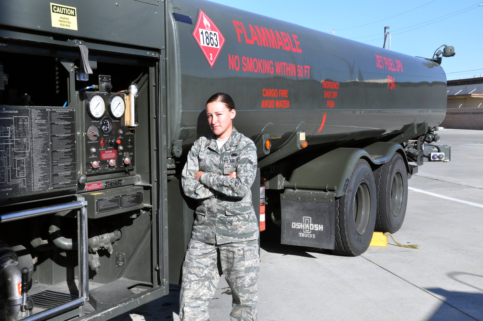 Airman 1st Class Corrie Smith, 60th Logistics Readiness Squadron fuels distribution technician, stands with an R-11 refueling truck 22 May in the fuels yard on base. Smith uses the vehicle to bring Jet Propellant-8 from bulk storage facilities to refuel Travis aircraft in her duties. (U.S. Air Force photo/Staff Sgt. Patrick Harrower)