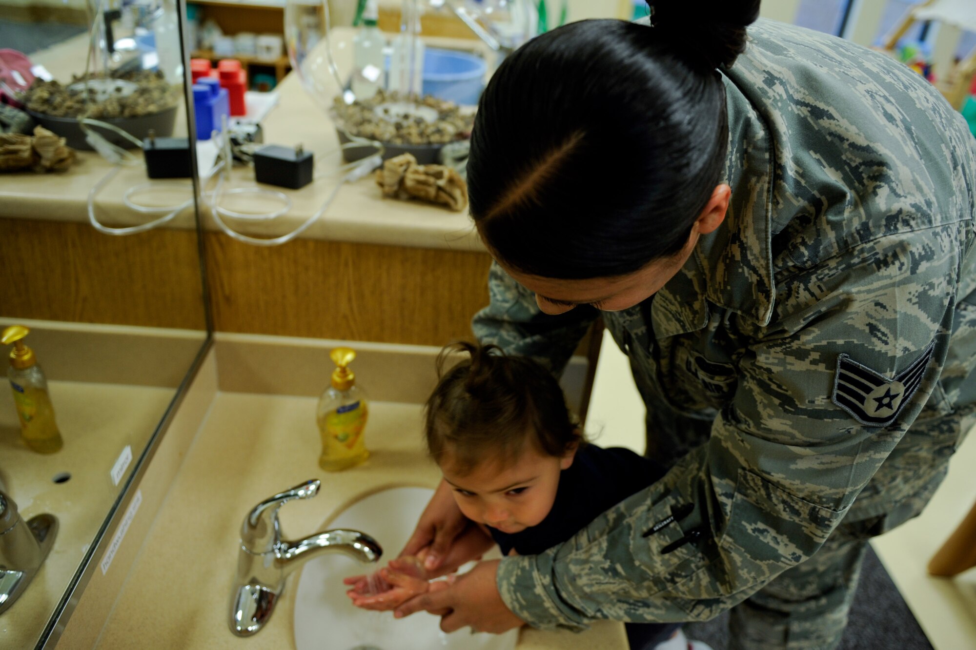 VANDENBERG AIR FORCE BASE, Calif. -- Staff Sgt. Veronica Hill, the 614th Air and Space Communications Squadron non-commissioned officer in-charge of information assurance, washes her daughter Cristianna's hands before leaving her at the new Child Development Center here Wednesday, May 23, 2012. The new CDC opened for business Monday and has the capacity to provide care for 172 children. (U.S. Air Force photo/Staff Sgt. Levi Riendeau)