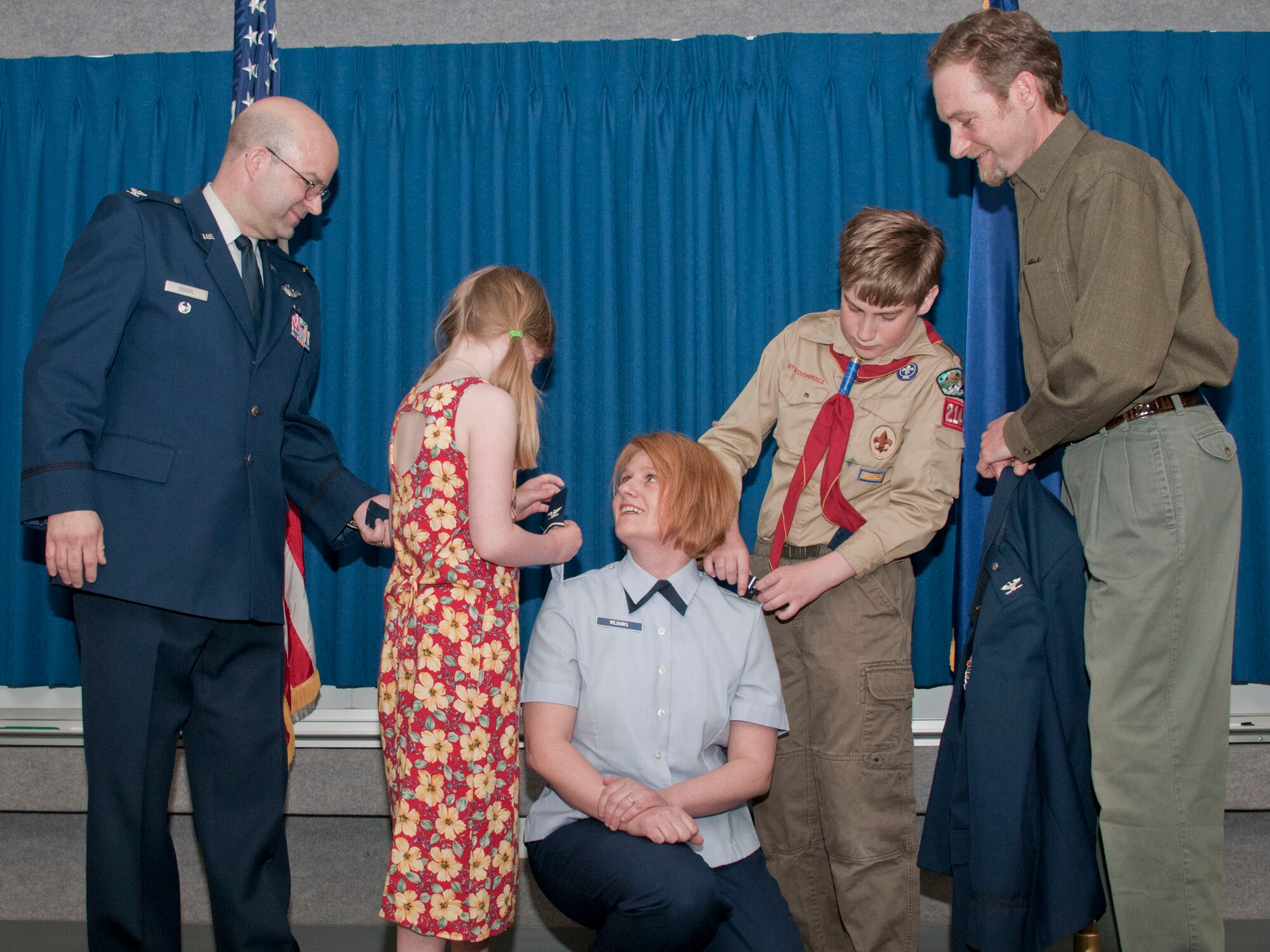 JOINT BASE ELMENDORF-RICHARDSON -- Lt. Col. Patty Wilbanks, commander of the 176 Mission Support Group, is promoted to full-bird colonel here May 20 with of help of her children. Col. Robert A. K. Doehl, vice commander of the 176 Wing, and Mr. Wilbanks stand by to assist. National Guard photo by Staff Sgt. N. Alicia Goldberger.