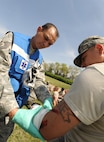 MINOT AIR FORCE BASE, N.D. -- Tech. Sgt. Bruce Collado, 5th Medical Operations Squadron aerospace medical technician, medically tends to a simulated patients arm wounds. Following a mock chemical attack at a simulated location on base, personnel from the 5th MDG were quick to respond to provide medical support. (U.S. Air Force photo/Senior Airman Jose L. Hernandez)