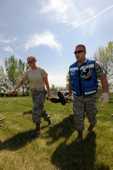 MINOT AIR FORCE BASE, N.D. -- With the help of a simulated patient who was able to provide manpower support, Staff Sgt. Robert Schaffer, 5th Medical Operations Squadron independent duty medical technician, transports a severely wounded moulage patient in a stretcher to safety. (U.S. Air Force photo/Senior Airman Jose L. Hernandez)