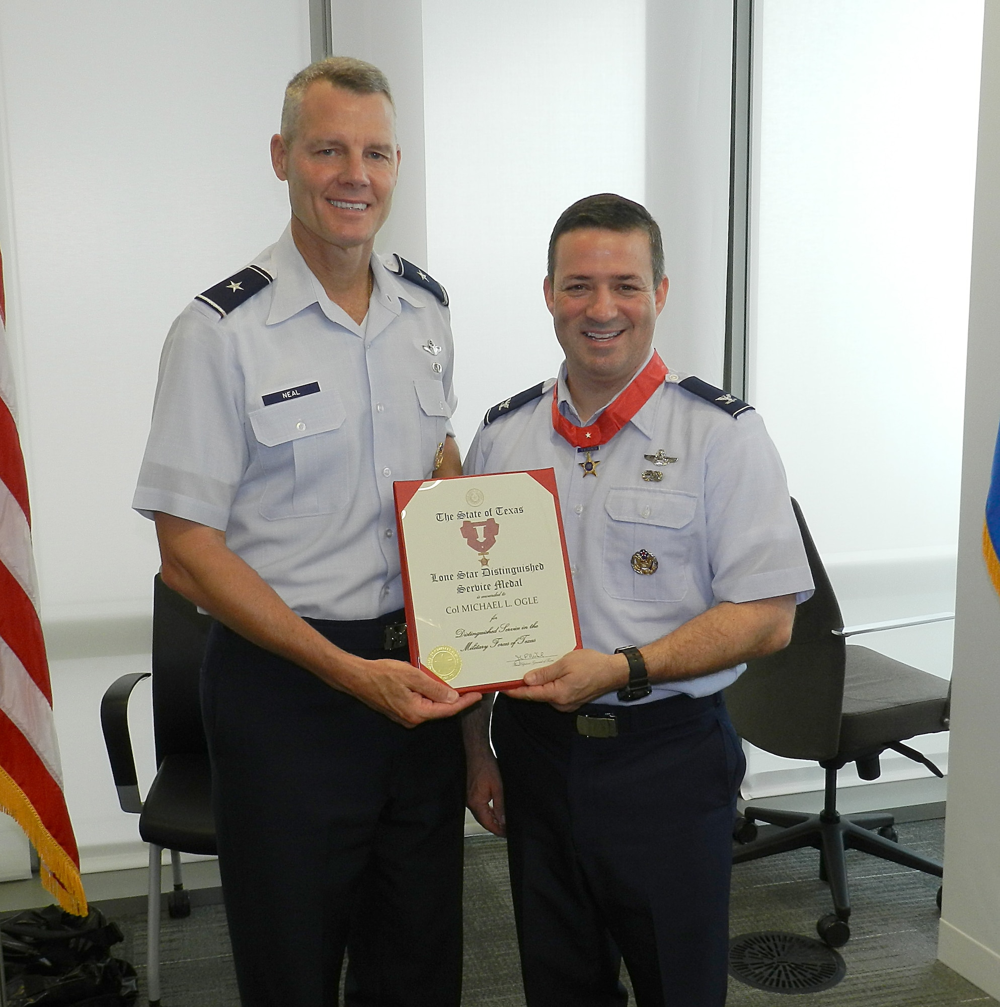 Brig. Gen. Brian Neal, the commander of the Air National Guard Readiness Center at Joint Base Andrews, Md., presents Col. Michael Ogle, the director of logistics for the ANG at the ANGRC, with the Lone Star Distinguished Service Medal from the state of Texas May 22, 2012 at the ANGRC for his exceptionally outstanding performance of duty while he was assigned to the 149th Fighter Wing, Lackland Air Force Base, Texas. The state of Texas awards the Lone Star Distinguished Service Medal to service members who while serving with the Texas military forces, distinguished themself by exceptionally outstanding achievement or service to the state in the performance of a duty of great responsibility and the Texas Adjutant General is the approving authority for this honor. (National Guard photo by Staff Sgt. Lorenzo Parnell/RELEASED)