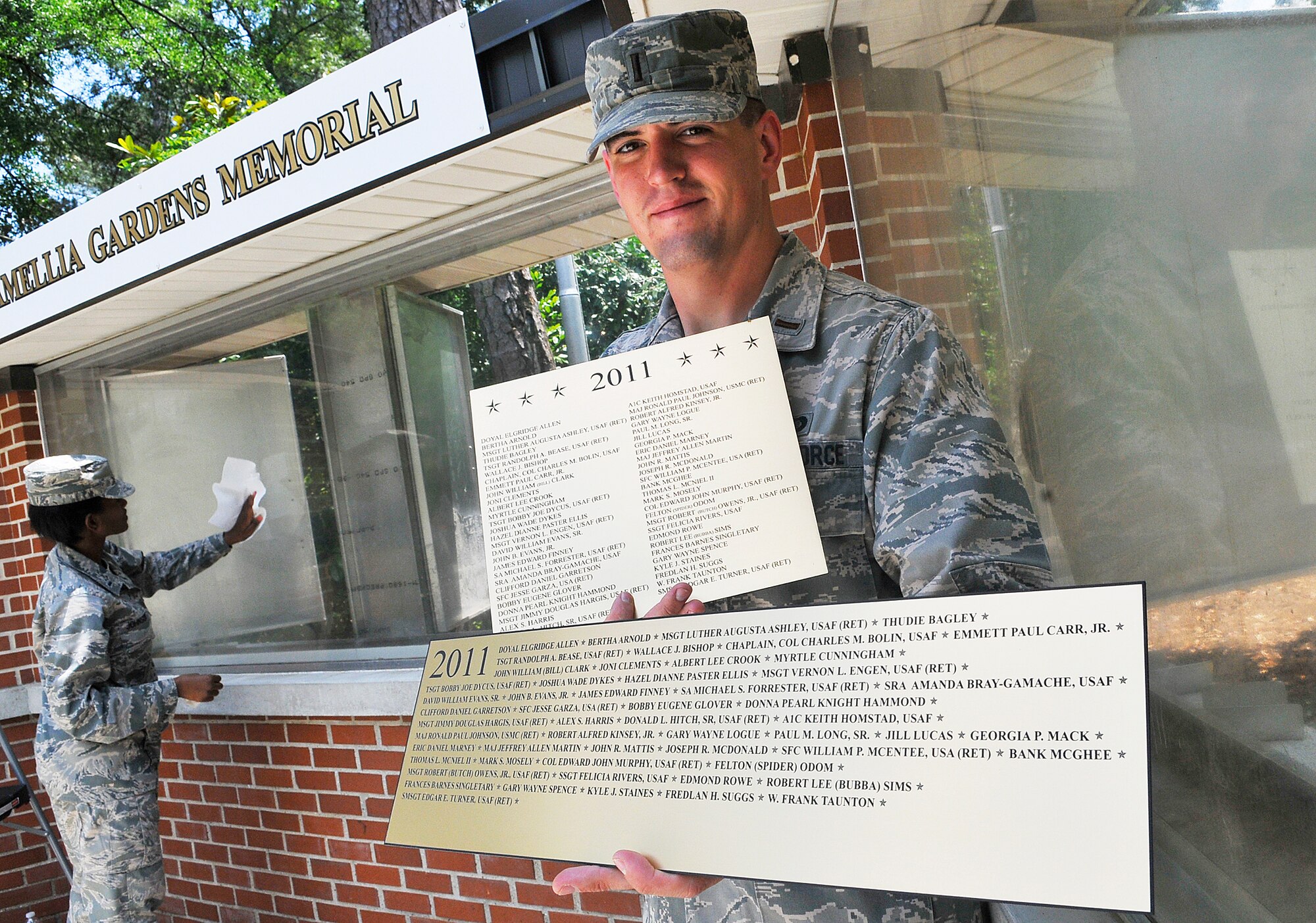 2nd Lt. Justin Baysden displays the new look of name plaques, shown at bottom, for the Camellia Garden Memorial, compared to the old plaques. The facelift of the memorial was a teaming effort which included the Base Chapel, 78th Civil Engineer Group, Youth Center and the Hobby Shop.  (U. S. Air Force photo by Sue Sapp)