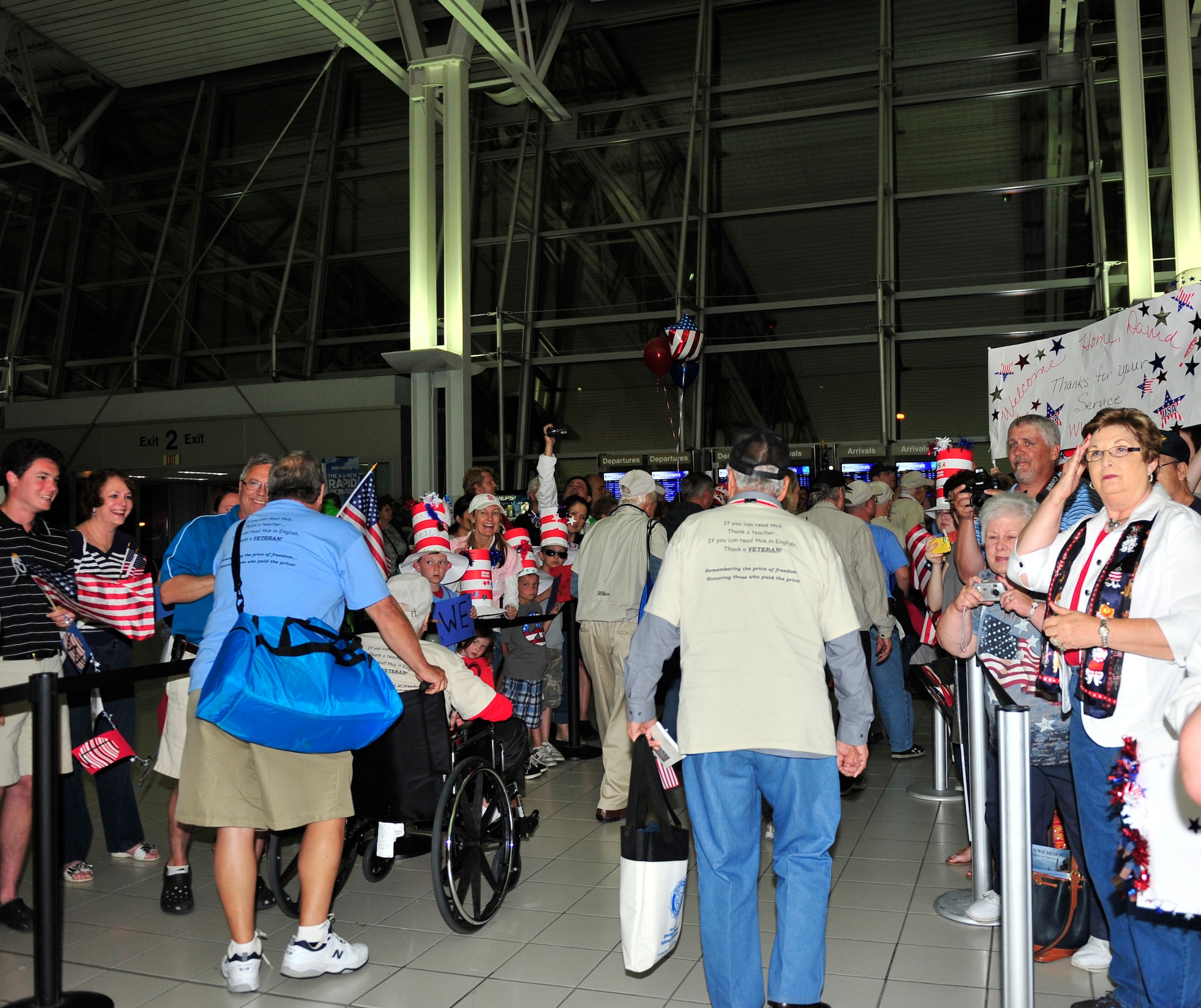 Their family members and friends cheer in the audience as they watch 26 World War II veterans be presented a photograph and letter of appreciation by active duty members assigned to Scott Air Force Base Ill., after their trip to the memorials in Washington D.C. May 21 sponsored by the Greater St Louis Honor Flight program. Honor flight is a program that transports World War II veterans once a month to in Washington, D.C. to view the National World War II, Korean war, Lincoln and Vietnam memorial, the a viewing of “The Changing of the Guard” at Arlington National Cemetery, Iwo Jima and ending with the U.S. Air Force memorial. For most of the veterans this was their first time viewing the memorials.  (U.S. Air Force photograph/ Staff Sgt. Stephenie Wade)