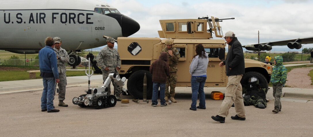 Airmen from the 28th Civil Engineer Squadron Explosive Ordnance Disposal team demonstrate and identify the equipment they use to accomplish their mission for visitors during Heritage Day at the South Dakota Air and Space Museum in Box Elder, S.D., May 19,2012.  Visitors were able to ask questions and gain insight as to what Airmen do on a day–to-day basis. (U.S. Air Force photo by Airman 1st Class Anania Tekurio/Released)