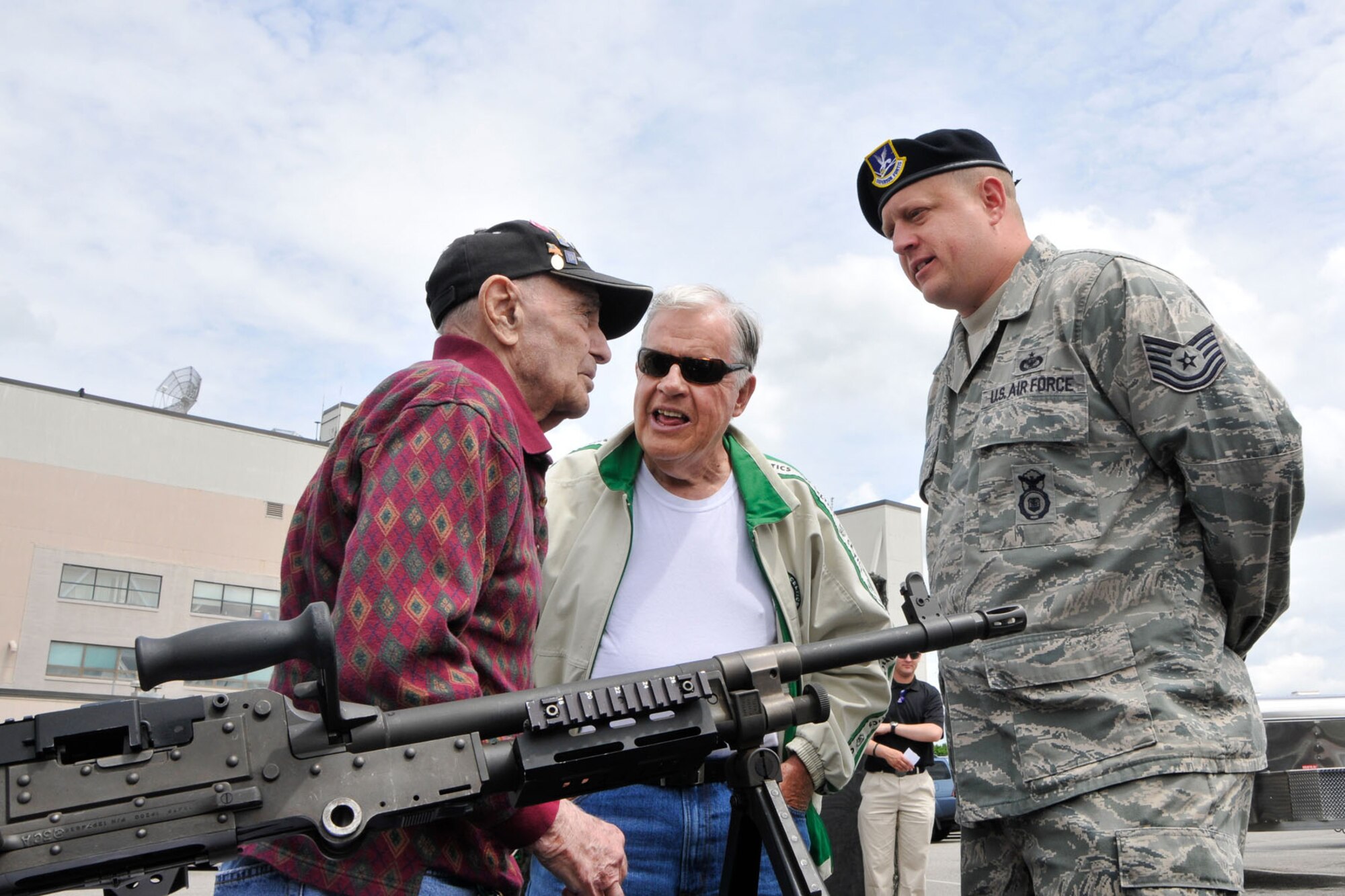 HANSCOM AIR FORCE BASE, Mass. – Tech. Sgt. Wayne Griggs, 66th Security Forces Squadron operations NCO in charge, speaks to a World War II veteran and other attendees during a weapons demonstration in the Base Exchange parking lot May 15. Security Forces were on hand for an equipment display, fingerprinting cards for kids, rides in the sky watch tower and the newly remodeled "Jail and Bail" display. (U.S. Air Force photo by Linda LaBonte Britt)