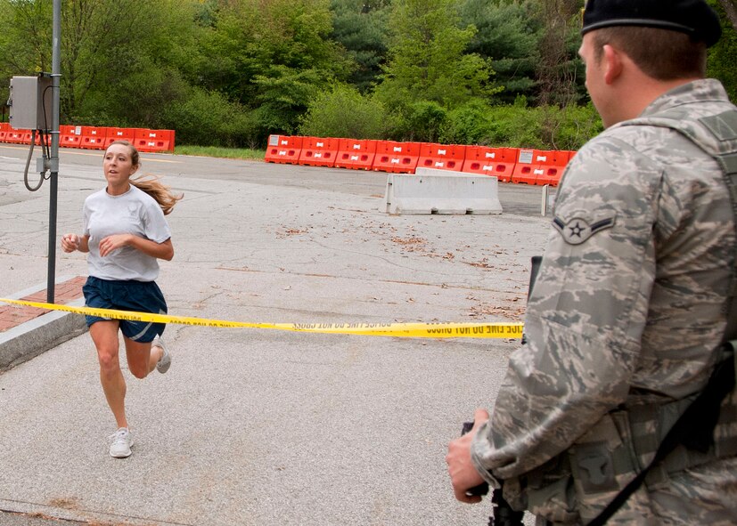 HANSCOM AIR FORCE BASE, Mass. -- Staff Sgt. Rachel Betts, 66th Security Forces Squadron pass registration clerk, crosses the finish line as the top female runner during a Police Week 5K through Minute Man National Historical Park. (U.S. Air Force photo by Mark Wyatt)