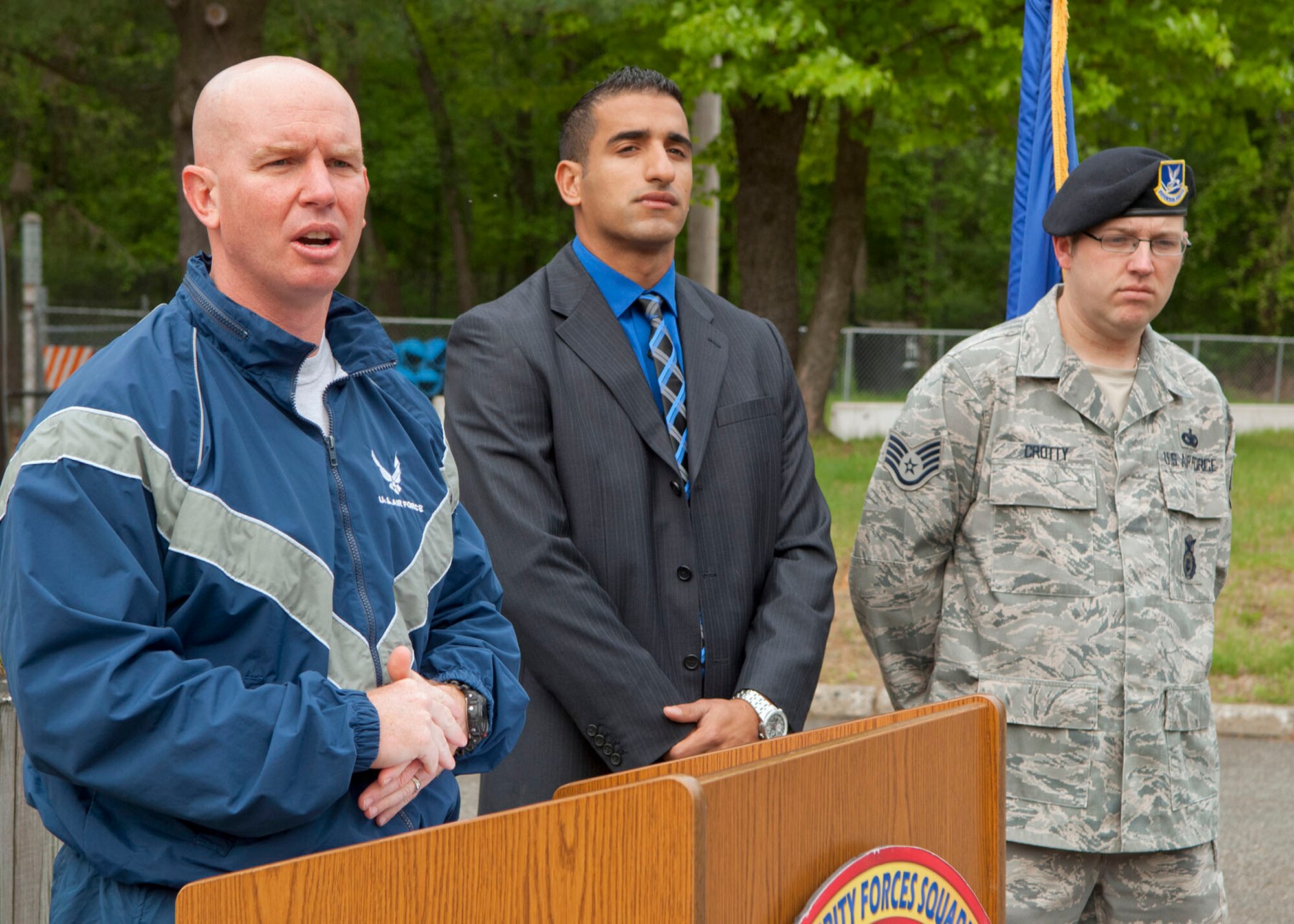 HANSCOM AIR FORCE BASE, Mass. -- Lt. Col. Derrick J. Weyland, 66th Security Forces Squadron commander, speaks during opening ceremonies of Police Week as (left to right) Special Investigator Elias Musallam and Staff Sgt. Richard C. Crotty look on. Opening ceremonies took place May 14 outside Building 1103 and a 5K run through Minute Man National Historical Park followed. (U.S. Air Force photo by Mark Wyatt)